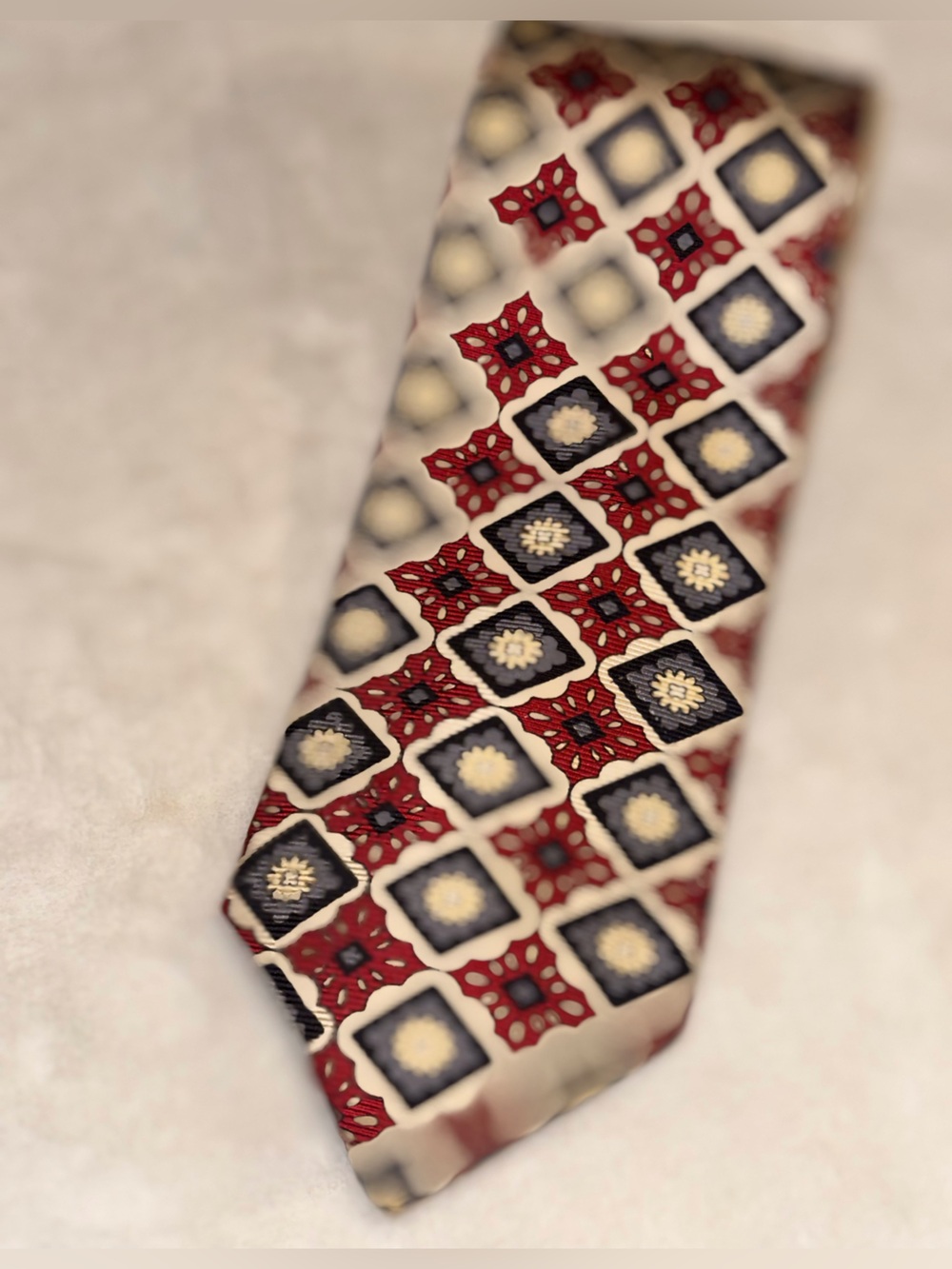 Tom James Silk Necktie featuring a detailed Burgundy/Grey Geometric medallion